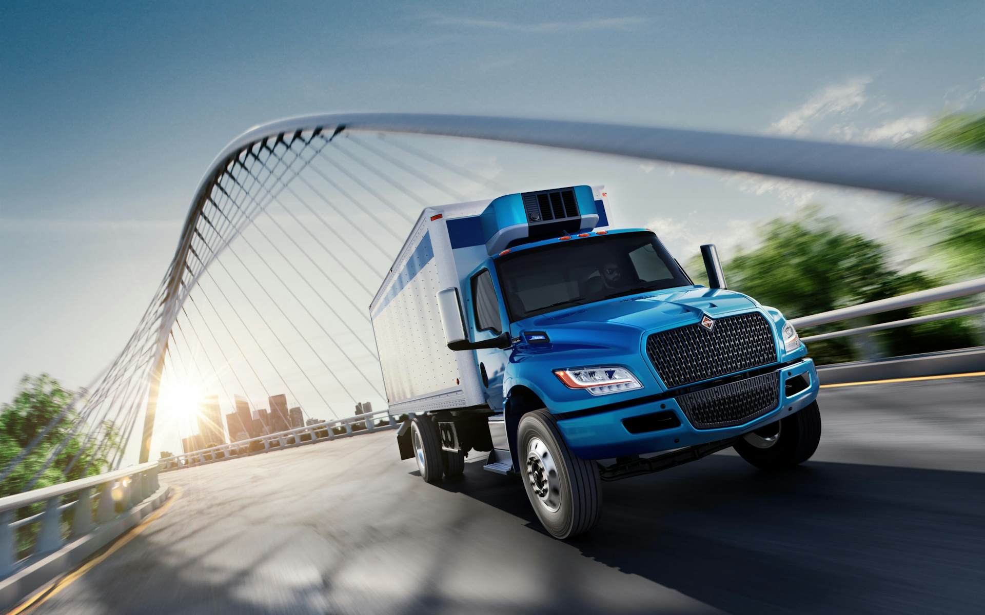 A blue truck driving on a bridge