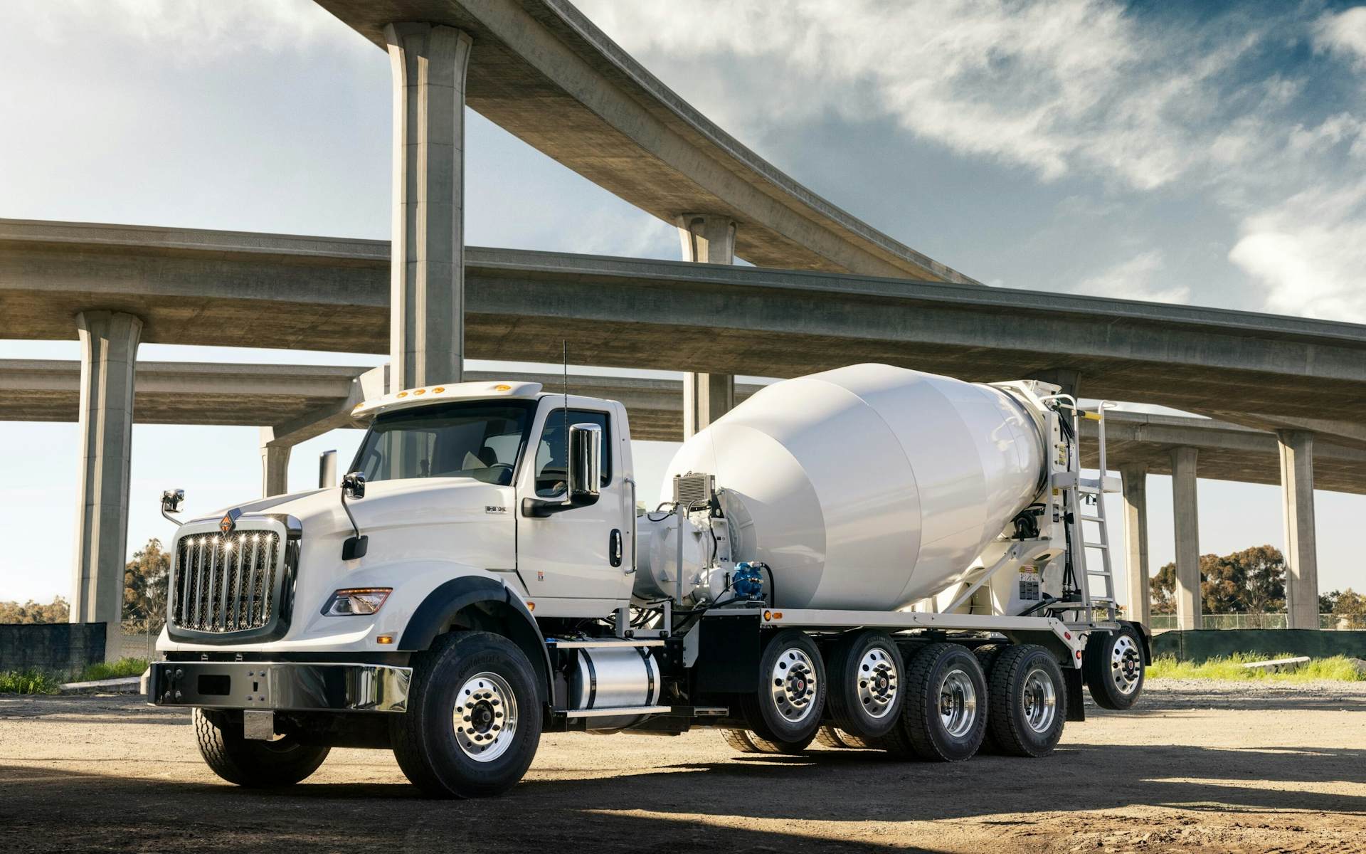 A white truck with a cement mixer on the side of it