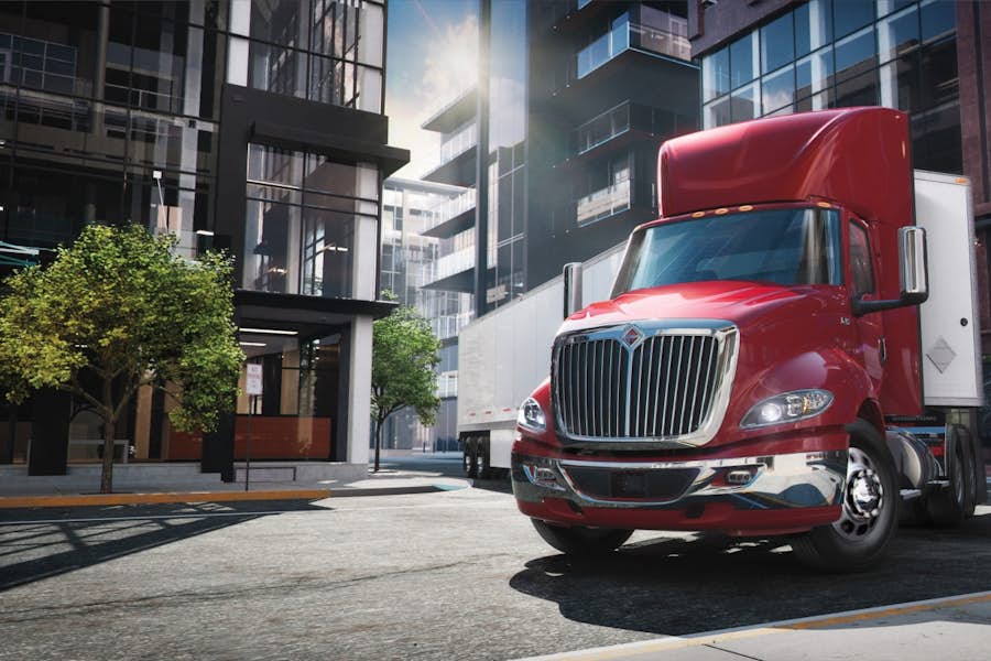 A red semi truck parked on the side of a road