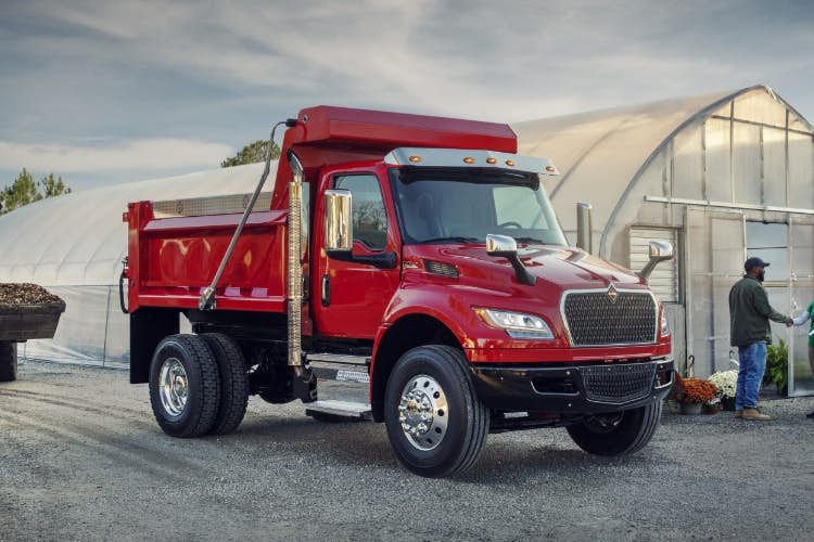 A red truck parked in a gravel area