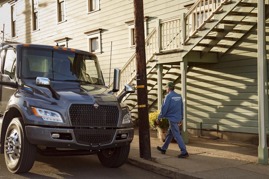 A person walking on the sidewalk next to a truck