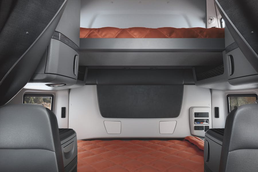 The inside of a vehicle with a bed and a mattress