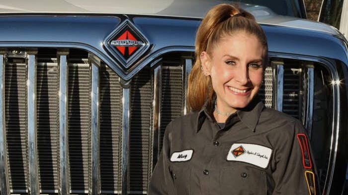 A person in uniform standing in front of a car